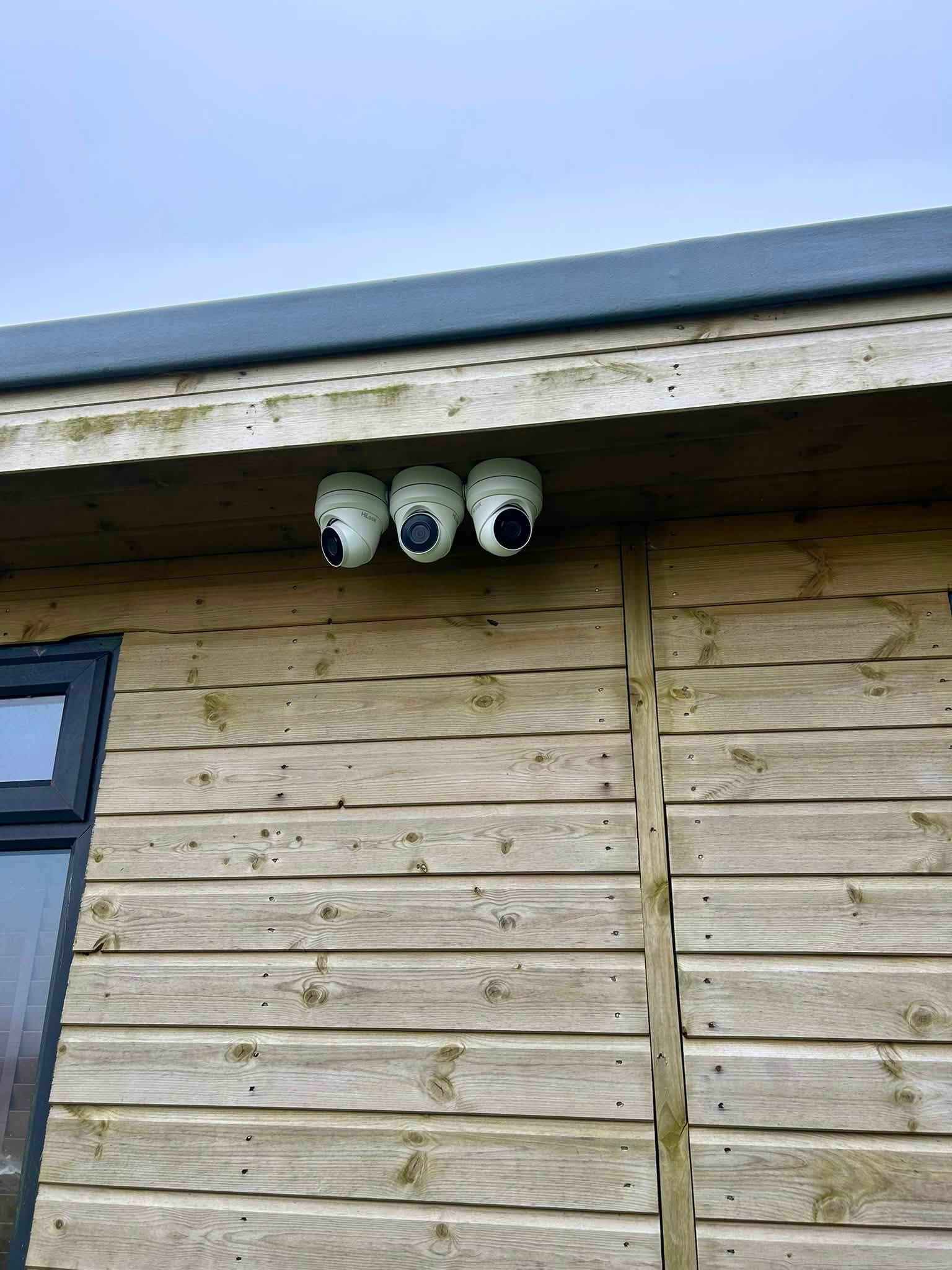 Three dome CCTV cameras installed by Celtic Security Solutions under a timber-clad eave